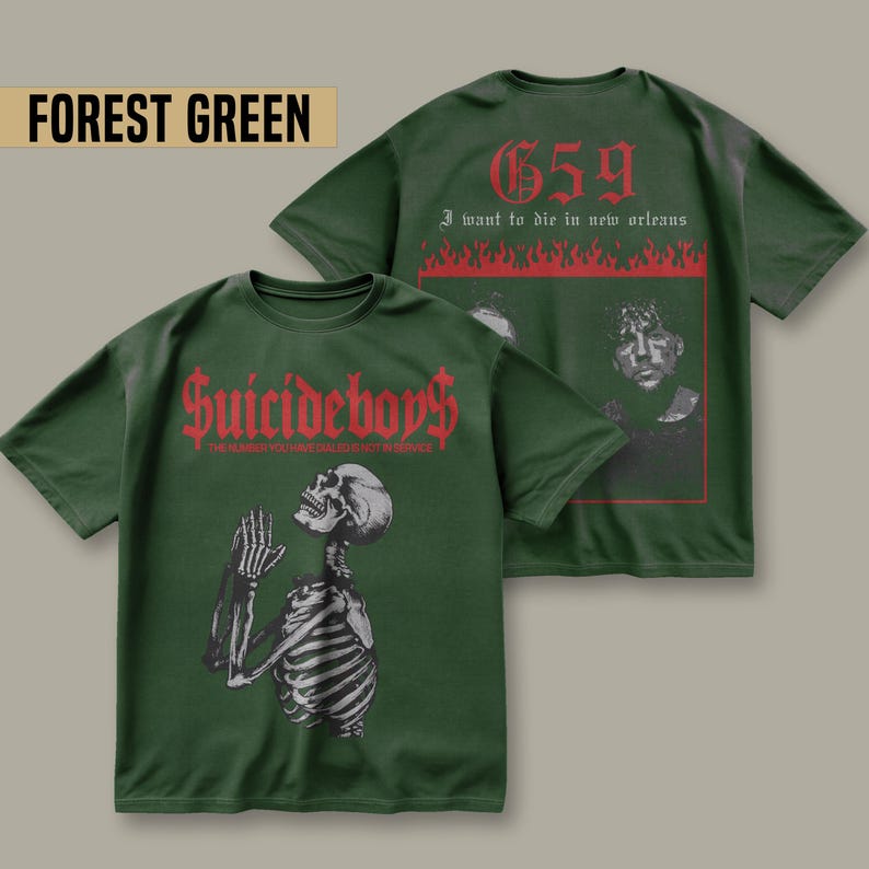 May include: Forest green t-shirt with a skeleton praying on the front and the text "Suicideboy$ THE MOMENT YOU WERE BORN YOU WERE ALREADY IN HELL" and on the back the text "659 I want to die in new orleans" with flames.