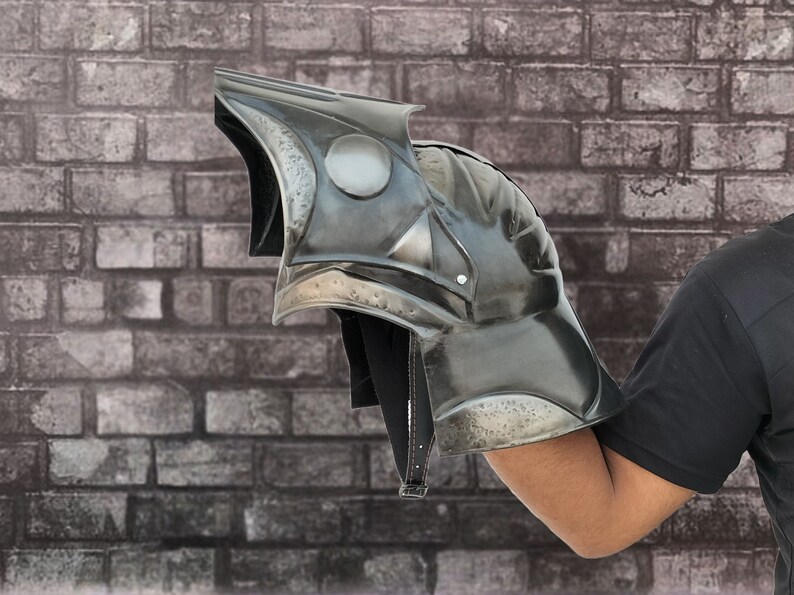 Op de afbeelding: Een zwarte metalen harnas handschoen met een getextureerd oppervlak en een puntig ontwerp. De handschoen wordt gedragen op de arm van een persoon.