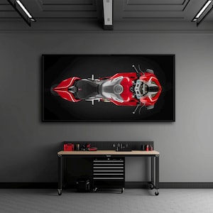 May include: A top-down view of a red and silver Ducati motorcycle displayed as a framed wall art piece. The motorcycle features a prominent red fuel tank, a black seat, and silver mechanical components, all set against a solid black background.