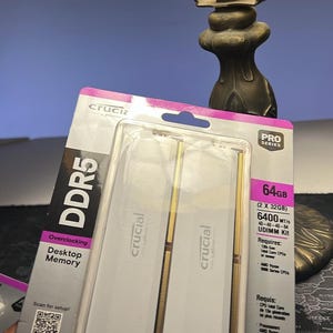 May include: A package of Crucial DDR5 Pro Series 64GB (2 x 32GB) desktop memory. The package includes two RAM sticks, each with a gold edge. The packaging has the Crucial logo and product specifications.