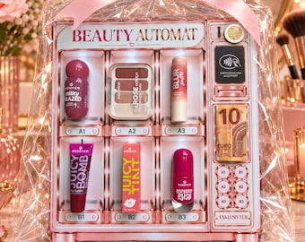 Puede incluir: Un set de regalo Beauty Automat en color oro rosa con forma de máquina expendedora, envuelto en plástico transparente con un lazo rosa. Contiene seis productos cosméticos Essence, incluyendo brillo de labios, sombras y esmalte de uñas.