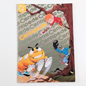 May include: A comic book cover featuring a yellow and orange cartoon centipede with a smiling face, wearing blue and white shoes. The centipede is flying through the air with its legs outstretched. The background is a green and brown tree with the words "Centipede" repeated in a pattern.