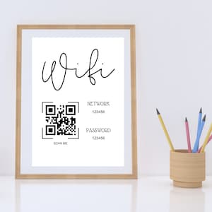 May include: A framed print with the word "wifi" written in cursive. A black and white QR code is below the word with the text "SCAN ME" underneath. The text "NETWORK 123456" and "PASSWORD 123456" are below the QR code.