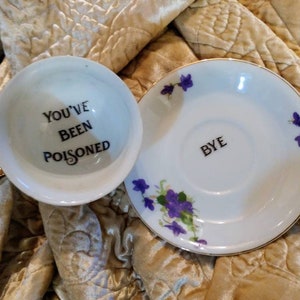 You&#39;ve been poisoned bye teacup saucer altered china gift custom purple pansy personalized poison cup message at bottom calligraphy murderin