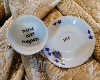 You've been poisoned bye teacup saucer altered china gift custom purple pansy personalized poison cup message at bottom calligraphy murderin