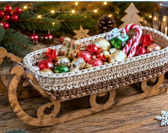 May include: A wooden sleigh with a two-toned beige and brown crocheted basket insert, filled with assorted wrapped candies and a candy cane. The sleigh measures 5.5-10-16 inches in length, width, and height respectively.