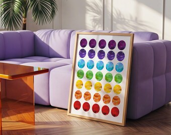 Può includere: Una stampa artistica incorniciata con un design ad acquerello di cerchi color arcobaleno. L'opera d'arte ha una cornice in legno naturale ed è esposta su uno sfondo chiaro. La stampa è appoggiata a un divano viola.