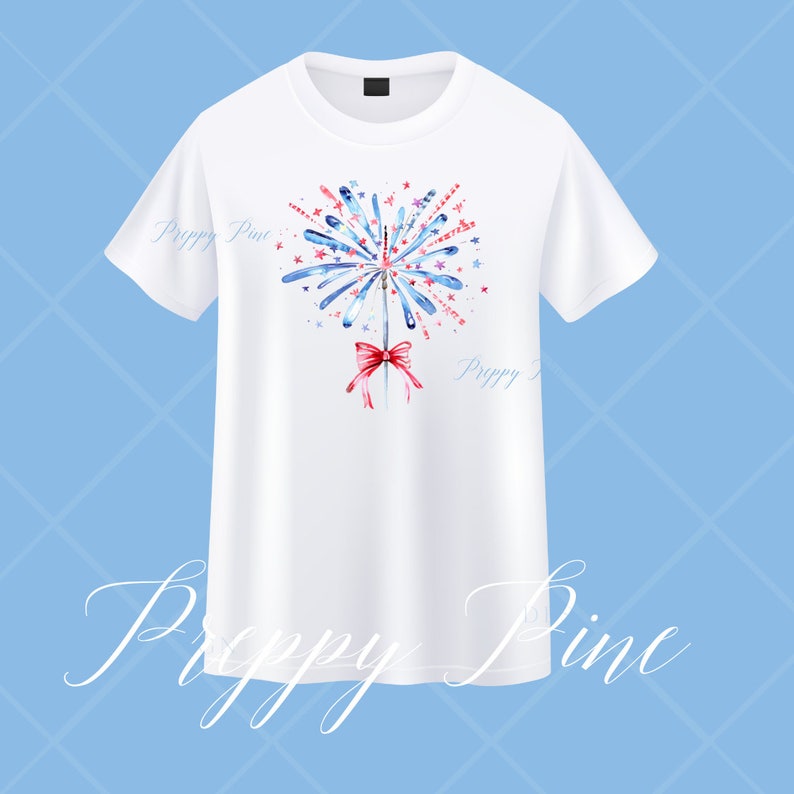 May include: White t-shirt with a watercolor design of a firework with red, white, and blue stars and a red bow. The text "Preppy Pine" is on the shirt.