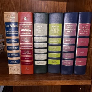 Może przedstawiać: Półka z książkami z serii Reader's Digest Condensed Books. Książki są oprawione w skórę i mają złote napisy. Tytuły to "To Kill a Mockingbird", "The Johnstown Flood", "Sadle Shays Matchmaker", "The Lord God Made Them All", "Mortal Fear" i "The Siege".