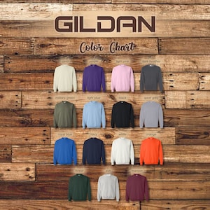May include: Color chart for Gildan sweatshirts showing 15 different colors: sand, purple, light pink, dark heather, military green, light blue, black, sport grey, royal blue, navy, white, orange, forest, ash, and maroon.