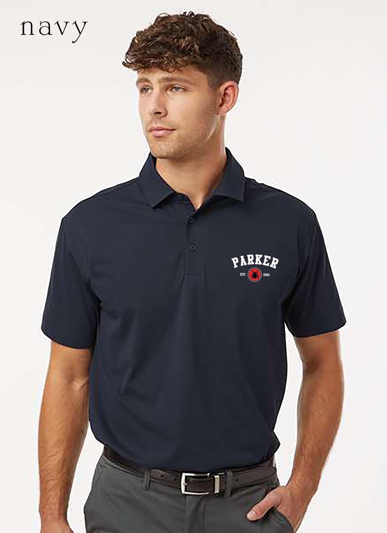 Puede incluir: Polo azul marino con cuello y mangas cortas. La camisa presenta la palabra "PARKER" en blanco sobre un dise&ntilde;o circular rojo y blanco. La palabra "navy" est&aacute; en la esquina superior izquierda.