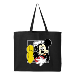 May include: Black tote bag featuring a graphic of Mickey Mouse in a relaxed pose. The cartoon character is outlined in black, with white gloves, a red shorts, and yellow shoes. The bag has a rectangular design.