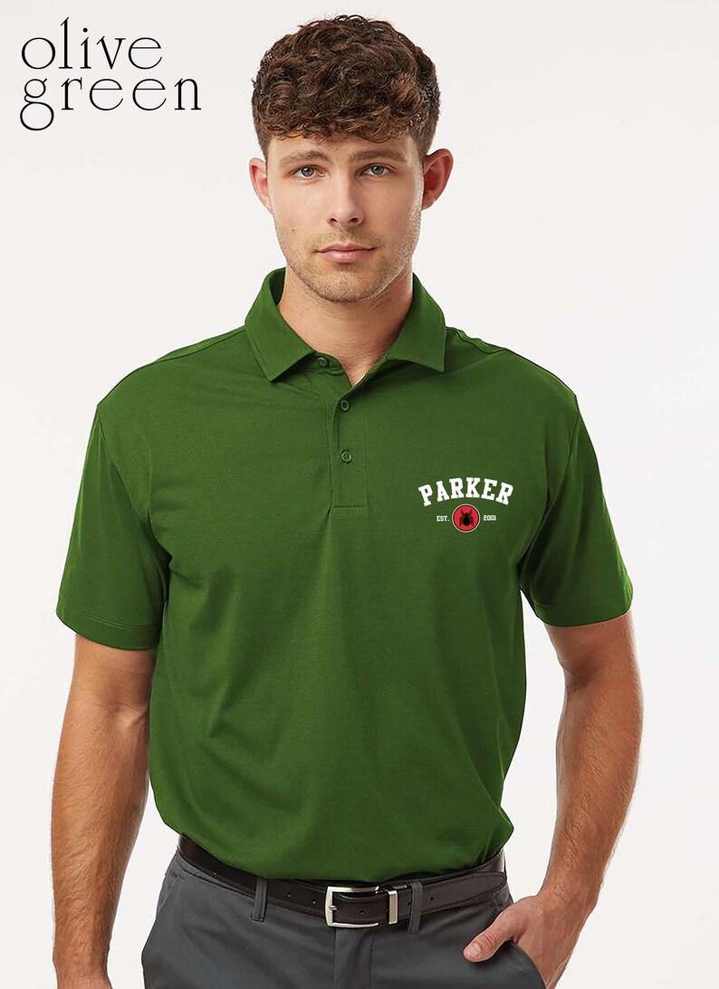 Puede incluir: Polo verde oliva con cuello y mangas cortas. La camisa presenta la palabra "PARKER" en letras blancas con un gr&aacute;fico rojo y negro. El texto "EST. 2005" est&aacute; debajo de la palabra "PARKER".