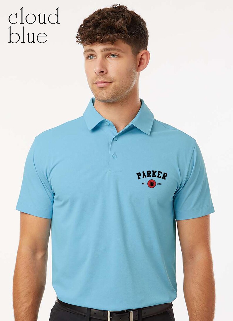 Puede incluir: Polo de color azul claro con cuello y mangas cortas. La camisa tiene la palabra "PARKER" en letras negras con un gr&aacute;fico rojo y negro. El texto "est. 2001" est&aacute; debajo de la palabra "PARKER".