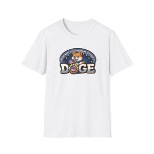Puede incluir: Camiseta blanca con un gráfico de un perro de dibujos animados sosteniendo una bandera estadounidense. El gráfico dice "Department of Government Efficiency DOGE".