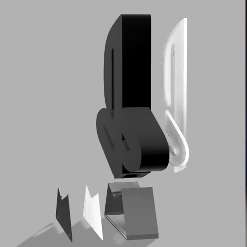 May include: A black and white PlayStation logo made of multiple pieces. The logo is made of a black base, a white outline, and a black top piece. The logo is sitting on a gray surface.