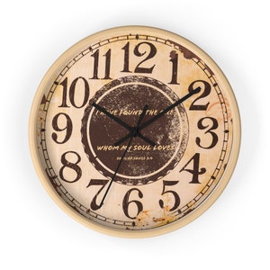 May include: A vintage-style wall clock with a distressed, beige background and brown accents. The clock face features Roman numerals and a circular design with the text "I've found the one whom my soul loves, Song of Songs 3:4".