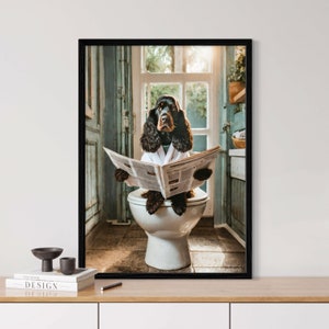 Puede incluir: Un perro Cocker Spaniel negro y marrón con una bata de baño blanca está sentado en un inodoro blanco en un baño, leyendo un periódico.