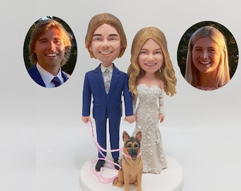 May include: A wedding cake topper featuring a caricature of a couple in a blue suit and a white dress, holding hands with a German Shepherd dog. The couple is holding a pink leash.