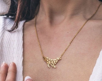 May include: A gold necklace with a geometric whale pendant. The whale is made of small triangles and is a modern and minimalist design.