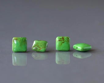 May include: Four square-shaped beads in a vibrant lime green color with natural brown veining patterns. The beads have a smooth, polished finish and are arranged in a horizontal row, each featuring a small hole for threading purposes.