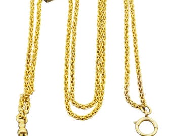Puede incluir: Un collar de cadena dorada con un colgante en forma de estrella. El colgante tiene una gema roja y blanca. La cadena está hecha de pequeños segmentos unidos. Un cierre es visible al final de la cadena.