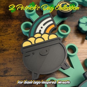 May include: A St. Patrick's Day Collection item featuring a black cauldron filled with yellow coins, topped with a rainbow. The text "St. Patrick's Day Collection" and "For Giant Lego-Inspired Wreath" are visible.