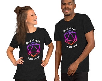 Puede incluir: Dos personas con camisetas de color gris oscuro. Cada camiseta presenta un diseño geométrico en morado, rosa y naranja, con el texto "I'm up all night to get lucky". Las camisetas son de estilo casual.