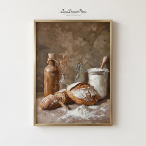 May include: A framed still life painting of bread-making ingredients. The painting shows a loaf of bread, sliced bread, and a jar of flour with a wooden spoon. The color palette includes browns, tans, and whites. The painting is signed "Luna Dream Prints".