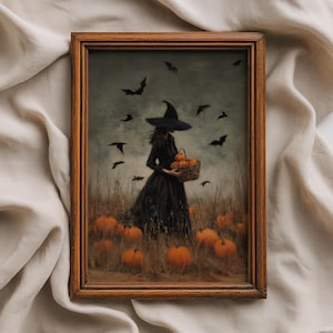 May include: A framed wall art print featuring a figure in a black dress and wide-brimmed hat standing in a pumpkin patch. The figure holds a woven basket filled with orange pumpkins. Dark silhouettes of flying bats fill the cloudy grey sky.