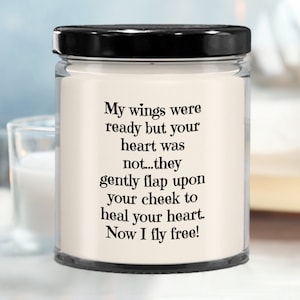 May include: A white candle with a black lid and a quote that reads: "My wings were ready but your heart was not...they gently flap upon your cheek to heal your heart. Now I fly free!"