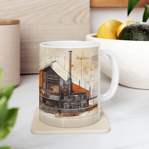 May include: White ceramic mug featuring a design of a building's cross-section, with orange and grey tones, and technical drawings on a beige background.