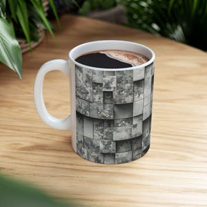 Könnte beinhalten: Eine weiße Keramik-Kaffeetasse mit einem Tarnmuster. Die Tasse ist mit Kaffee gefüllt.