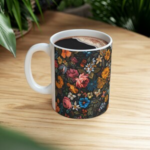 Peut inclure: Une tasse en céramique blanche avec un motif floral noir. La tasse est remplie de café.