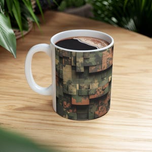 Könnte beinhalten: Eine weiße Keramik-Kaffeetasse mit einem Tarnmuster. Die Tasse ist mit Kaffee gefüllt.