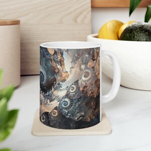 May include: White ceramic mug with a colorful abstract design featuring swirling patterns in shades of brown, blue, and white.