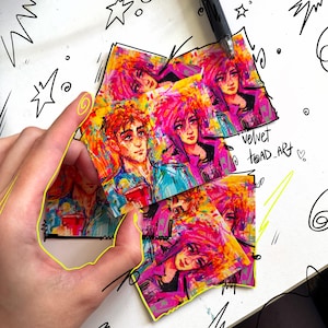 May include: A collection of rectangular art prints featuring vibrant, expressive portraits with neon pink, yellow, and blue brushstrokes. The prints display stylized characters with intense gazes. The text velvet toad_art is written in black ink.