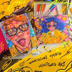 May include: Two colorful acrylic paintings of expressive faces, one with glasses and tongue out, the other with blue hair. A box of markers and the text "commissions open" and "VELVETTOAD ART" are also visible.