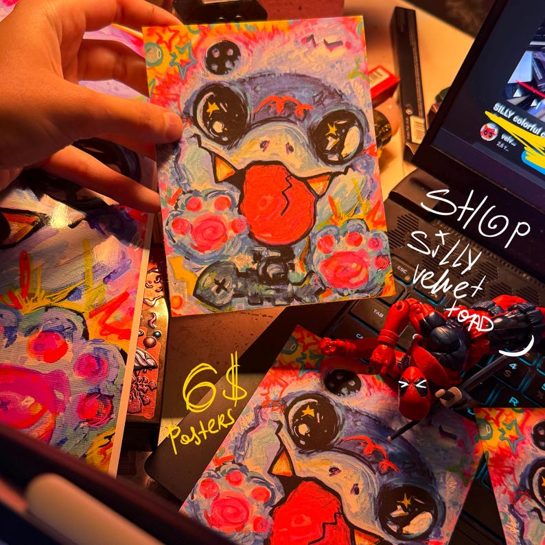 K&ouml;nnte beinhalten: Sechs bunte Poster mit einer Comicfigur mit einer gro&szlig;en Zunge und leuchtenden Augen. Die Figur ist von einem bunten Hintergrund mit einem psychedelischen Muster umgeben. Die Poster sind in einem Shop namens "Silly Velvet Toad" erh&auml;ltlich.
