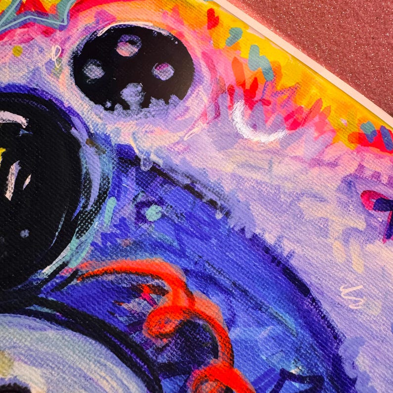 K&ouml;nnte beinhalten: Abstraktes Gem&auml;lde mit leuchtenden Farben, darunter Pink, Gelb, Blau und Rot. Das Gem&auml;lde zeigt einen gro&szlig;en schwarzen Kreis mit kleineren Kreisen darin und eine wei&szlig;e Halbmondform.