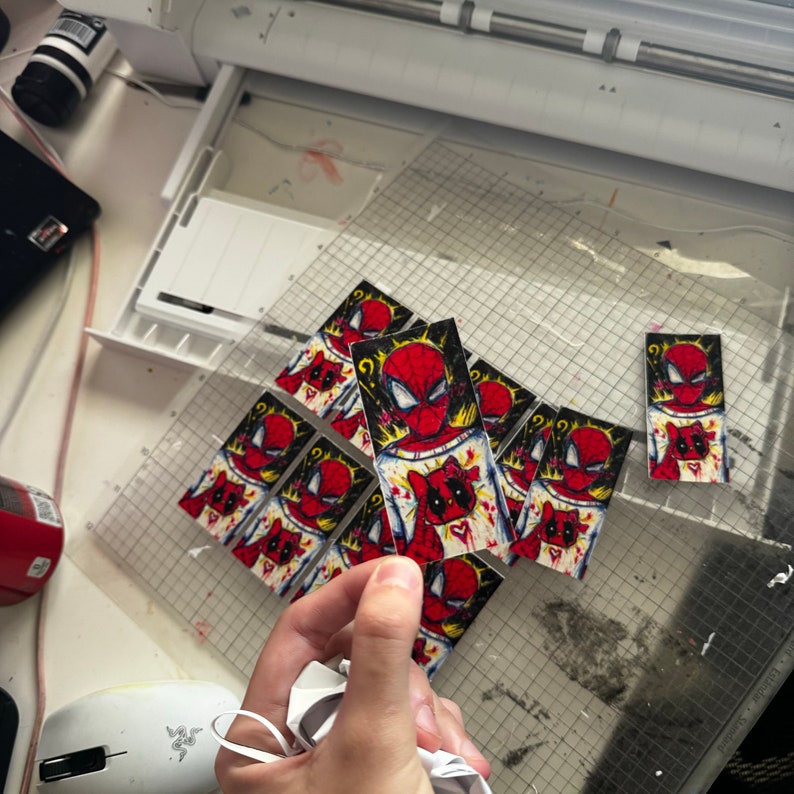 Puede incluir: Una colecci&oacute;n de pegatinas coloridas con un personaje de superh&eacute;roe de dibujos animados con un traje rojo y azul. Las pegatinas est&aacute;n impresas en papel blanco y tienen un contorno negro. Las pegatinas est&aacute;n dispuestas en un patr&oacute;n de cuadr&iacute;cula.