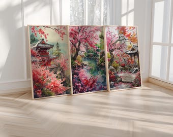May include: Three framed watercolor paintings depicting a Japanese garden scene with cherry blossoms, a traditional temple, and a pond. The paintings are in a light wood frame and are hung on a white wall.