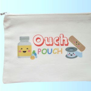 May include: A white canvas pouch with a red zipper pull and the words "Ouch Pouch" in colorful letters. The pouch features cartoon illustrations of a medicine bottle, pills, a bandage, and a roll of tape.