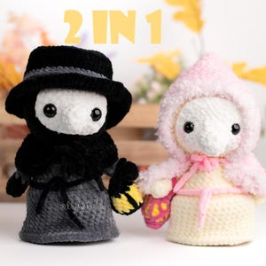 May include: Two crocheted plush toys, one in black and gray with a long nose and a hat, and the other in pink and white with a long nose and a hood. The text "2 IN 1" is visible above the toys.