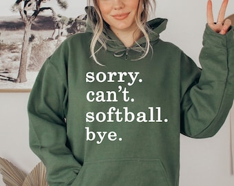 May include: Green hooded sweatshirt with the text "sorry. can't. softball. bye." in white.