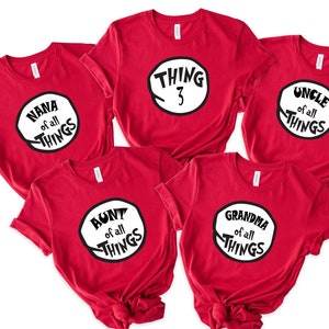May include: Set of six red t-shirts with white text and a black circle design. The text on the shirts reads "Nana of all things", "Thing 3", "Uncle of all things", "Aunt of all things", "Grandma of all things".