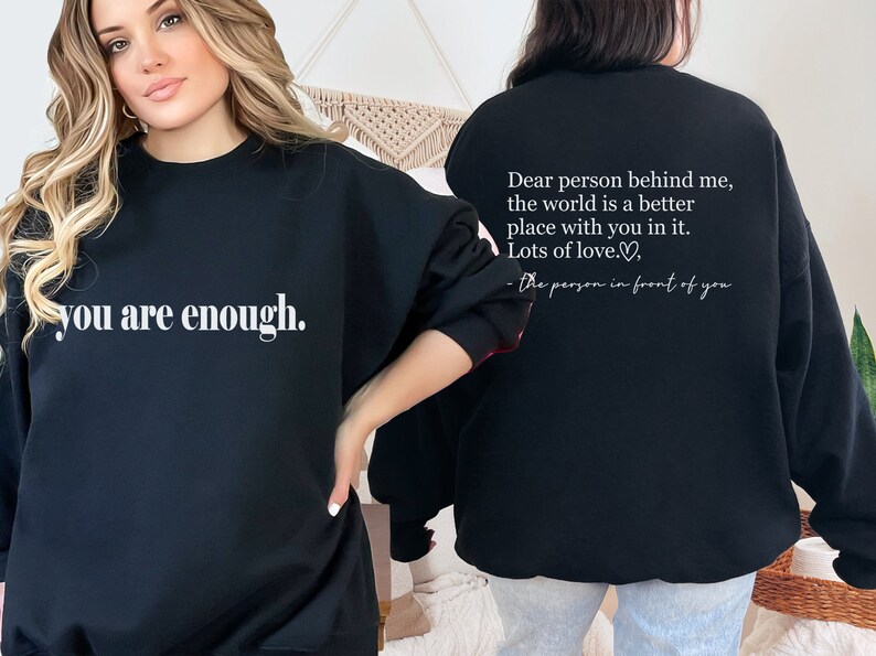 May include: Black sweatshirt with the text "you are enough." on the front and the text "Dear person behind me, the world is a better place with you in it. Lots of love. - the person in front of you" on the back.