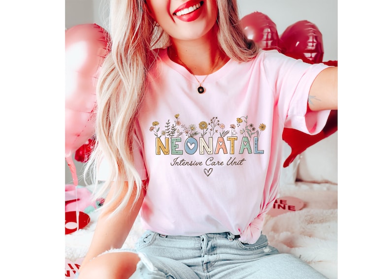 May include: A pink t-shirt with the text "NEONATAL Intensive Care Unit" in colorful letters with a small heart in the middle of the word "NEONATAL". The letters are surrounded by small flowers.