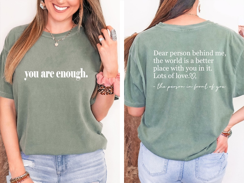Pu&ograve; includere: Una maglietta verde con la scritta "you are enough." sul davanti e la scritta "Dear person behind me, the world is a better place with you in it. Lots of love. - the person in front of you" sul retro.