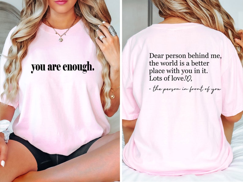 Pu&ograve; includere: Maglietta rosa con la scritta "you are enough." sul davanti e la scritta "Dear person behind me, the world is a better place with you in it. Lots of love.♡, - the person in front of you" sul retro.